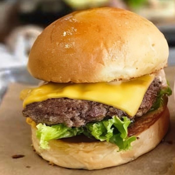 A Bunz Handcrafted Burger with a beef patty, melted cheese, and fresh lettuce on a bun.