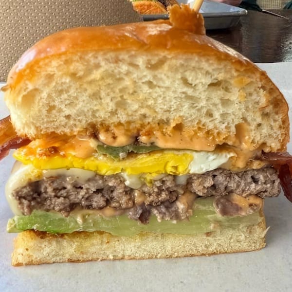 Cross-section of a Bunz burger with bacon, egg, avocado, patty, and special sauce.
