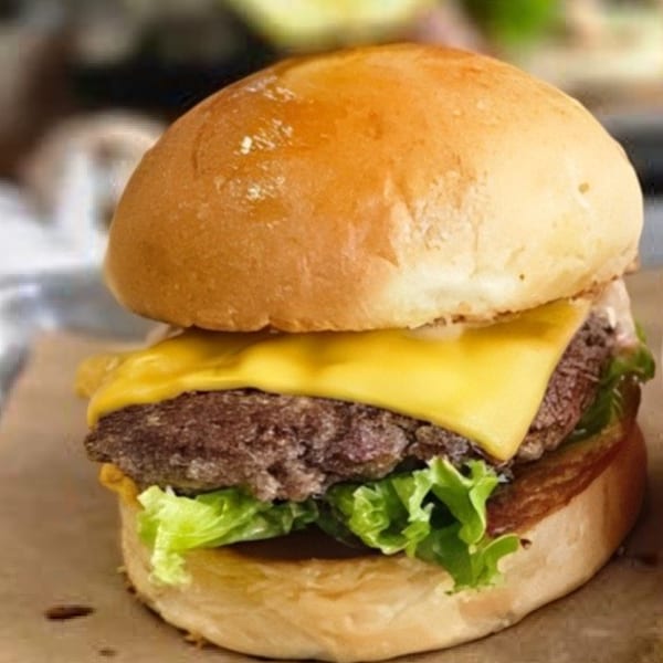 A Bunz Handcrafted Burger with a beef patty, melted cheese, and fresh lettuce on a bun.